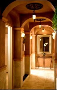 A beautifully renovated hallway with arched doorways and decorative lighting by Halpin Hands in Williams, OR.