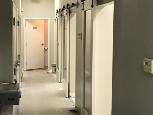 A newly installed barn door in a hallway with an unfinished floor by Savage Construction in Cordova, TN.