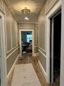 A newly painted hallway with decorative wall molding and a new light fixture by Tribute Painting & Drywall in St. Louis, MO.