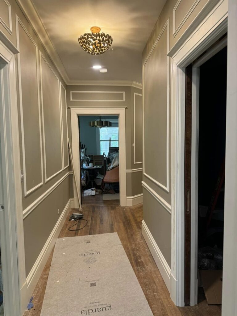 A newly painted hallway with decorative wall molding and a new light fixture by Tribute Painting & Drywall in St. Louis, MO.