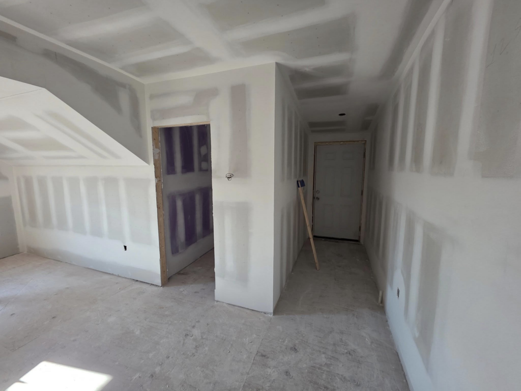 Hallway and room with new drywall installation and remodeling work by J M Construction & Remodeling in Humble, TX.