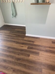 A renovated hallway with new wood laminate flooring and fresh paint, completed by Newhouse Construction St Louis in St. Louis, MO.