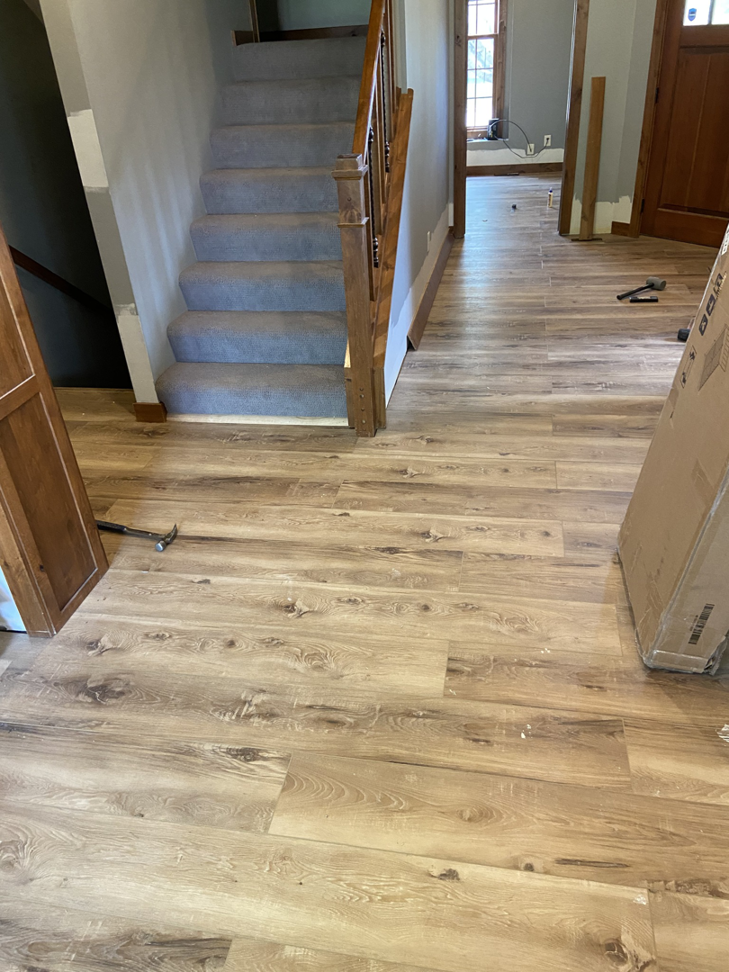 Renovated hallway with new laminate flooring and a carpeted staircase, a project by RT Handyman LLC in Sioux Falls, SD.
