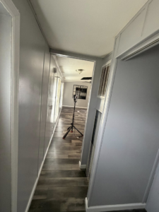 A renovated hallway with new dark laminate flooring and freshly painted gray walls, part of a home update by Hard Knox Handyman in Knoxville, TN.
