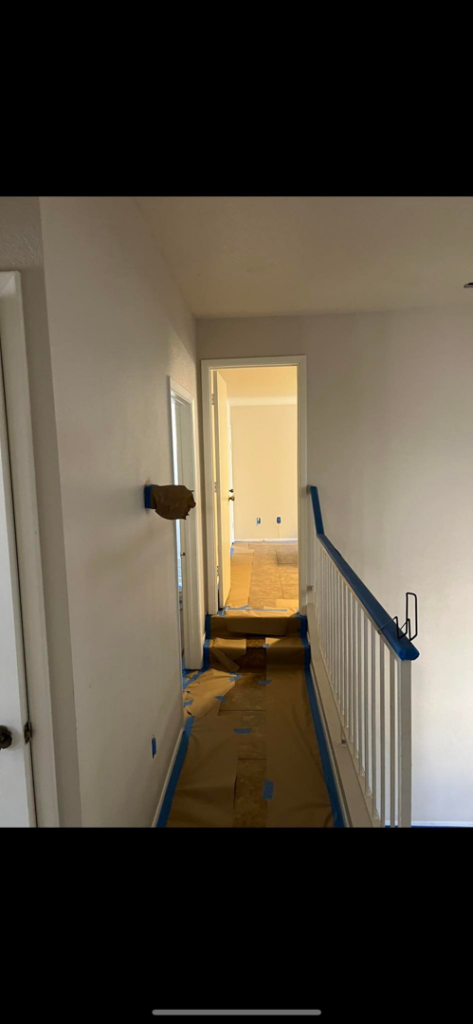 Hallway with painter's tape and floor protection, showing painting preparation by Arizona Contracting And Remodeling LLC in Tucson, AZ