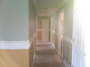 Hallway with fresh paint and new wainscoting trim installed by Castillo Construction Company in Malden, MA