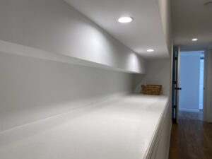 Finished hallway with modern recessed lighting and built-in shelves installed by AES Electrical Contractor in Richmond, VA.