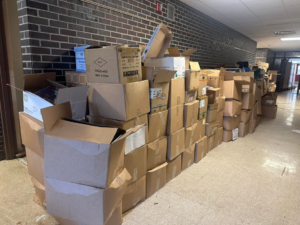 A hallway lined with stacks of cardboard boxes ready for recycling and removal by Remove Recycle Remarket in Troy, MI.