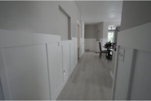 A hallway featuring newly installed white wainscoting and light-colored flooring by Will.B.More Handyman & Remodel in West Jordan, UT