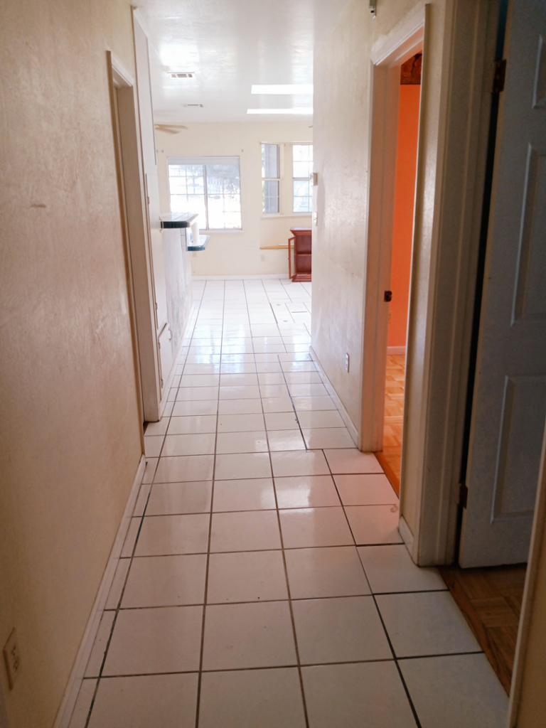 A clean hallway featuring newly installed white tile flooring, completed by AJR Cleaning & Handyman Service in Bakersfield, CA.