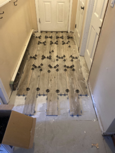 Hallway wood-look tile installation in progress by Main Street Handyman, LLC in Winter Garden, FL.