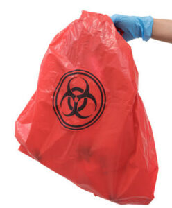 A gloved hand holding a red biohazard waste bag, representing specialized junk removal services by Affinity Bio Solutions in Phoenix, AZ.