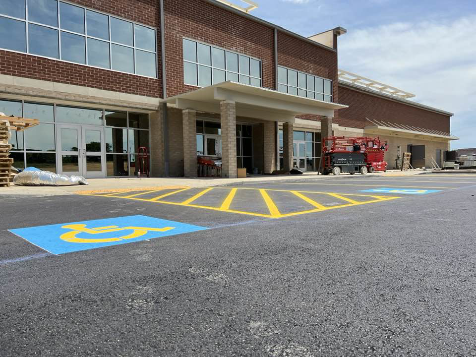 A newly striped handicap parking stall with blue and yellow markings by Marine One Striping in Clarksville, TN.