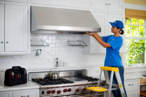 A Handyman Connection technician adjusting a kitchen range hood in a home in Fort Collins, CO