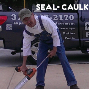 A handyman applying concrete sealant to a driveway or patio for Concrete Crack Repair and Sealer - DrivewayDr.com in Saint Louis, MO.