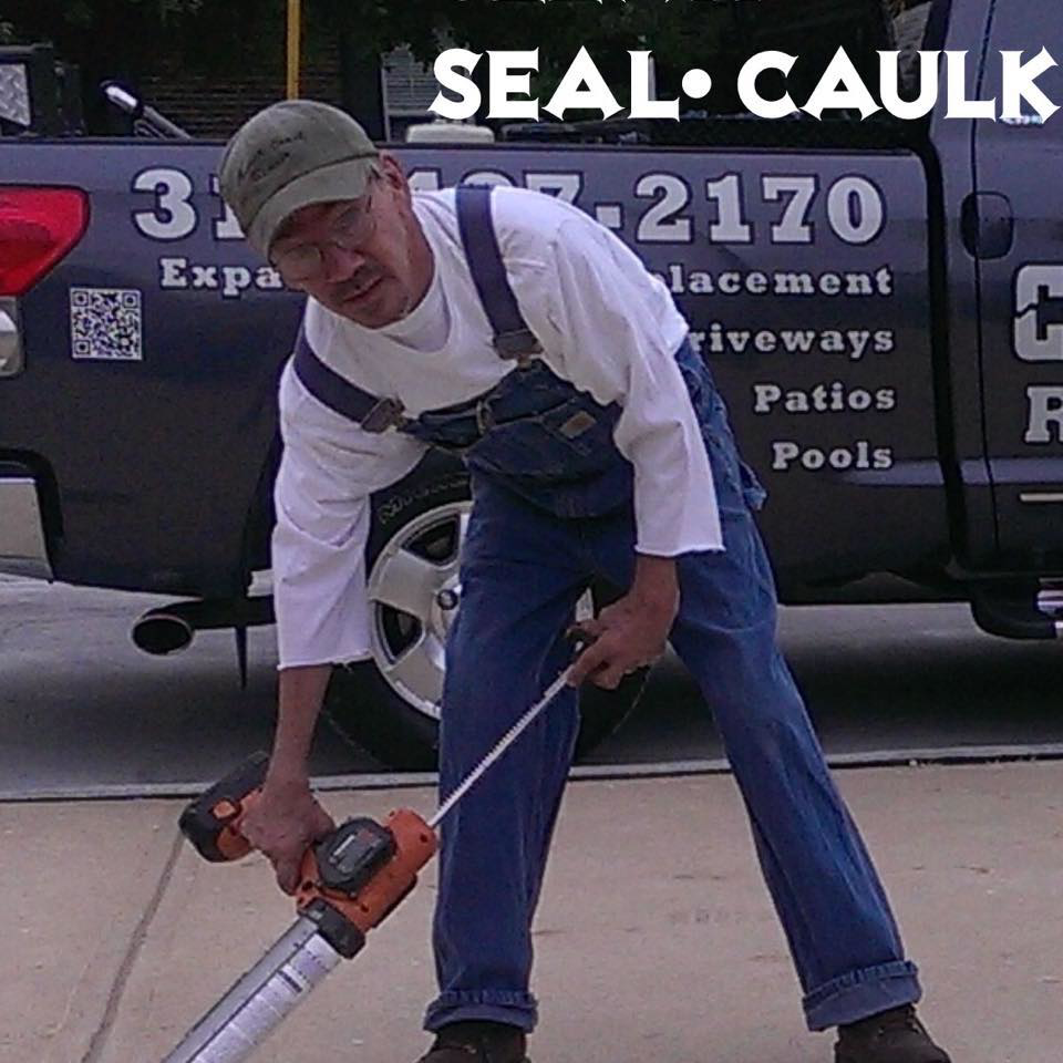 A handyman applying concrete sealant to a driveway or patio for Concrete Crack Repair and Sealer - DrivewayDr.com in Saint Louis, MO.