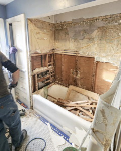 A handyman performing bathroom renovation and demolition work, removing old fixtures for Brian's Tiles in Duluth, MN.