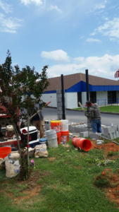 Handyman workers constructing a cinder block wall for Diversified Construction in Huntsville, AL.