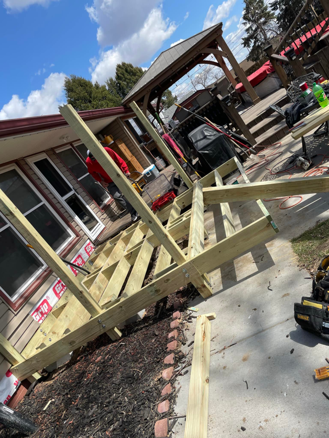 A handyman working on the wooden frame of a new deck installation by B&B Handyman Solutions in Omaha, NE.