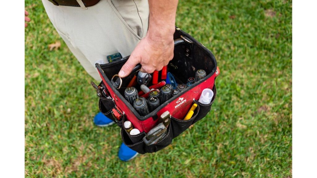 A handyman carrying a red tool bag filled with tools for Advanced Rooter Plumbing in Norwalk, CT