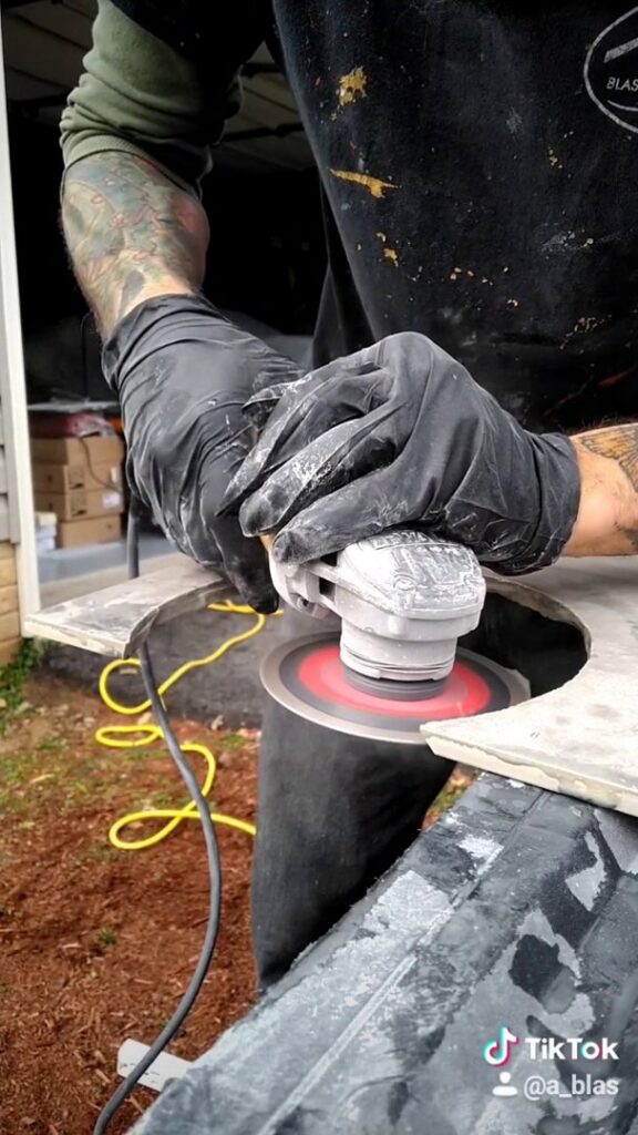 A handyman from Blas Home Remodeling LLC in New Castle, DE, using an angle grinder to cut material during a renovation project.