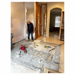 A handyman from Tom Broglia Building & Remodeling Services demolishing kitchen floor tiles during a renovation in Boise, ID.