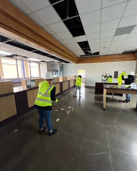 A handyman team sweeping demolition debris in a commercial space for Ringenberg Construction, LLC in Virginia Beach, VA.