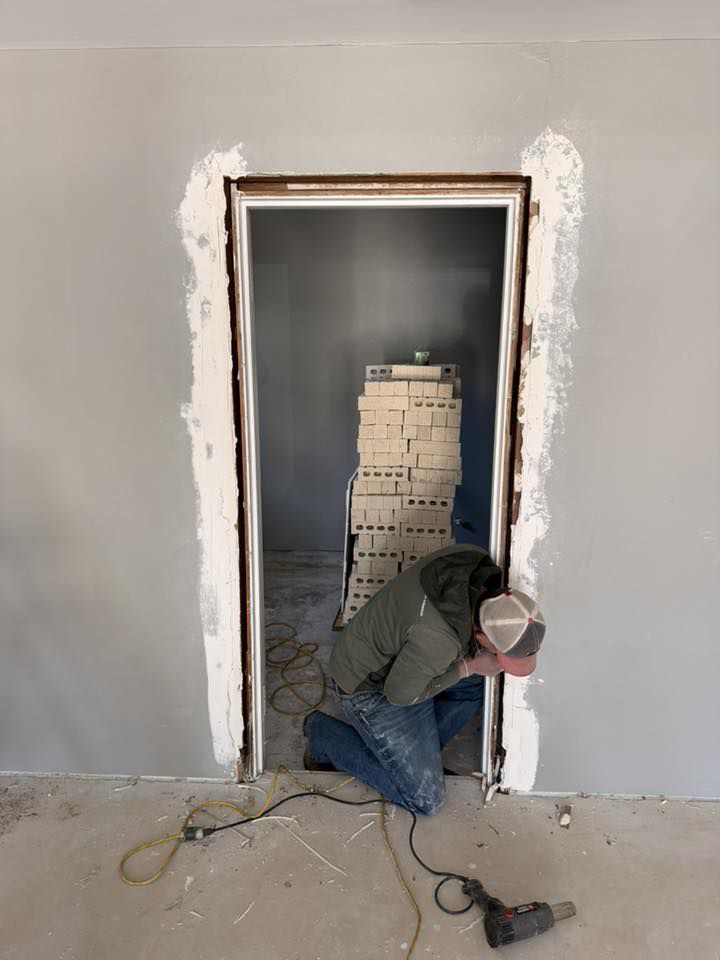 A handyman performing door frame repair and installation for S&B Construction Services in Shreveport, LA.