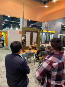 A handyman demonstrating door installation and repair techniques at a workshop for BFC Construction in Tacoma, WA.