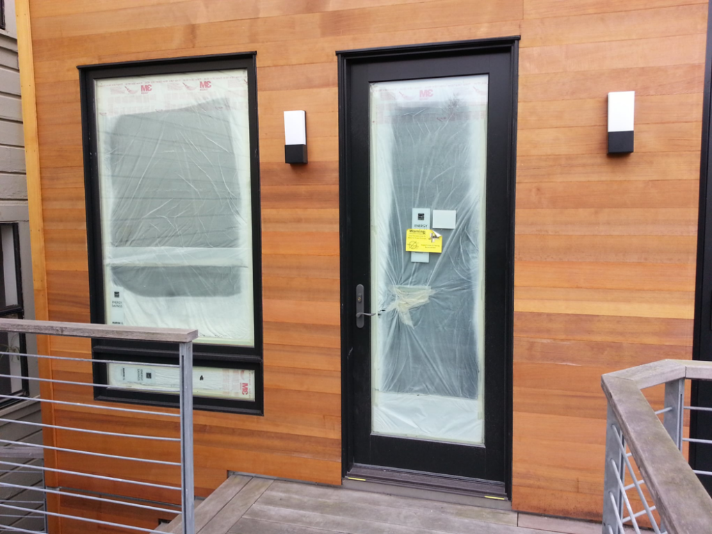 A newly installed door and window on a building exterior by Tycon Builders Inc in San Francisco, CA
