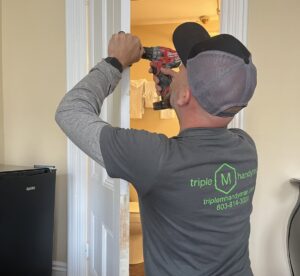 A handyman from Triple M Handyman drilling a door frame during an installation in Portsmouth, NH.