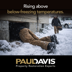 A handyman from Paul Davis Restoration entering a snowy crawl space for repairs in Louisville, KY