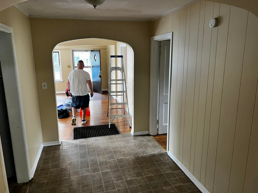 A handyman entering a room with a ladder and tools, ready to start a job for Star Mountain Realty LLC in Roanoke, VA.
