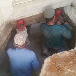 A handyman crew from House Leveling and Foundation Repair LLC performing foundation repair and house leveling in Denver, CO.