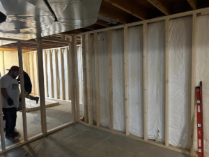 A handyman from Jewell Services framing new basement walls during a home renovation project in Des Moines, IA.