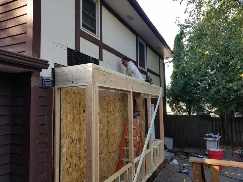 A handyman working on the wood framing of an exterior home addition for Gerlach Handyman in Eau Claire, WI.