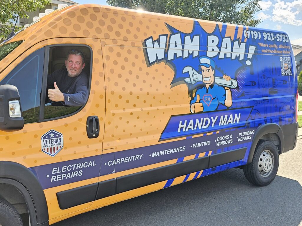 A handyman giving a thumbs up from his branded service van for Wam Bam Handyman LLC in Colorado Springs, CO