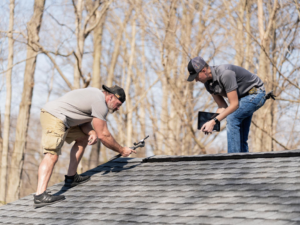 Two handymen from Big Boy's Construction INC inspecting a residential shingle roof in Indianapolis, IN.