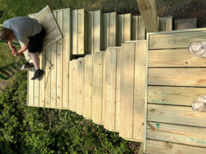 An overhead view of a handyman installing wooden deck stairs for a client of Aaron's Handyman Service in Tucson, AZ.