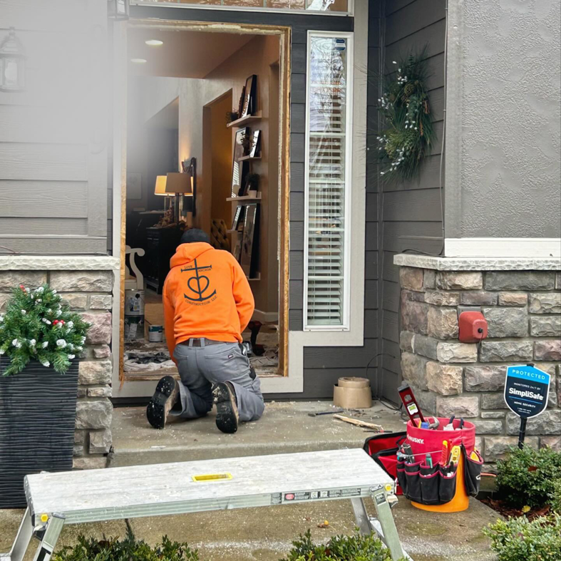 A handyman from Love Anchor Construction LLC installing a new door frame at a home entrance in Vancouver, WA.