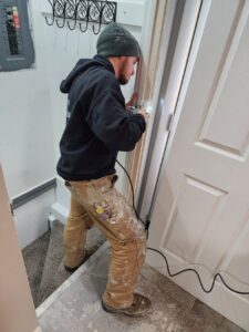 A HandyMation professional installing door trim with a power tool in Cheyenne, WY