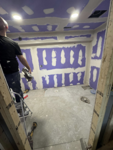 A handyman installing drywall during a bathroom renovation project for Home Improvements by Duane in Racine, WI.