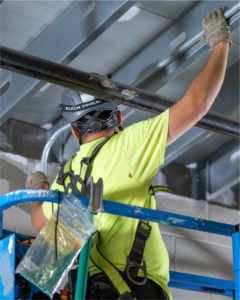 A handyman from M&L Electrical, Inc. installing electrical conduit from a scissor lift in Bowling Green, KY.