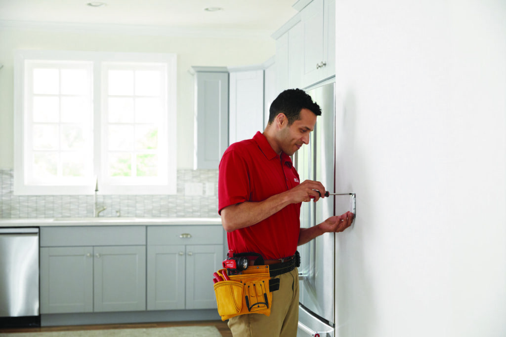 A handyman from Westlake Ace Handyman Services Kansas City Metro installing an electrical outlet in a kitchen in Lenexa, KS.