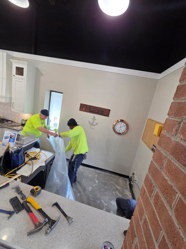 Handyman professionals installing new flooring at Carpet Hut by McDrake in Virginia Beach, VA.