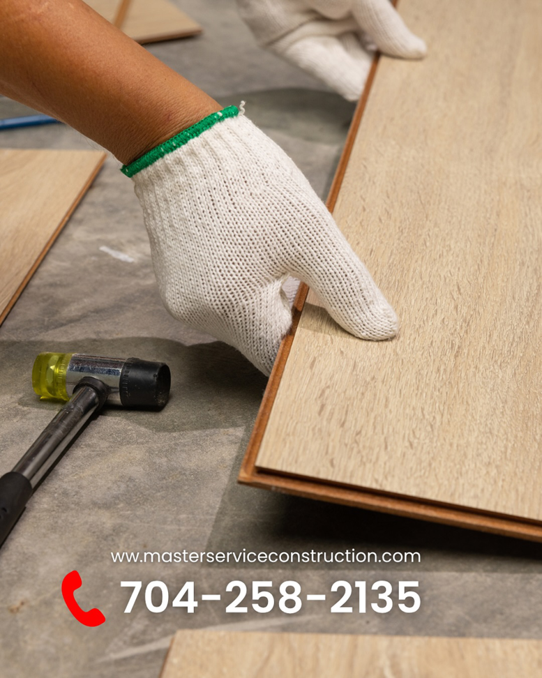A handyman installing new flooring planks for Master Service Construction Corporation General Contractor in Charlotte, NC