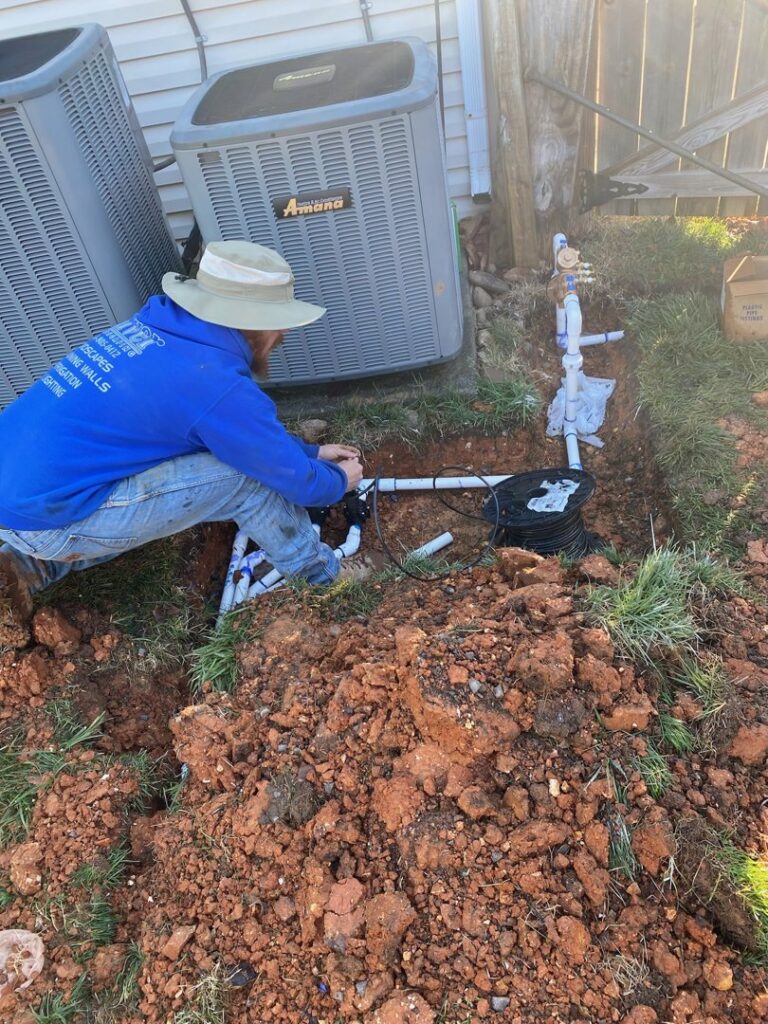 A handyman from Silver Landscaping & Construction installing an irrigation system in Knoxville, TN