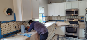 A handyman installing a kitchen backsplash at a client's home, provided by JJU Property Maintenance, LLC in Salem, OR.