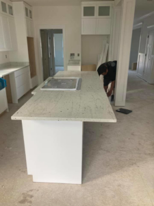 A handyman installing a kitchen island countertop for Diamond Stone Works in Virginia Beach, VA