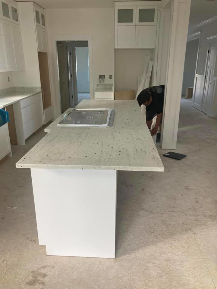 A handyman installing a kitchen island countertop for Diamond Stone Works in Virginia Beach, VA